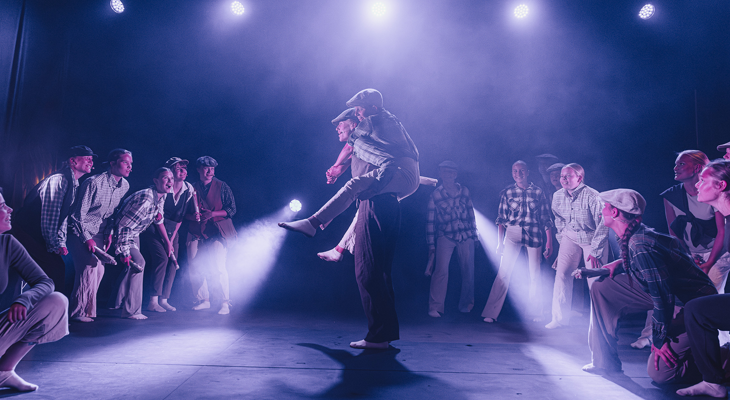 Ungdommer på en scene, der en gutt bærer en annen på ryggen mens flere står rundt dem.