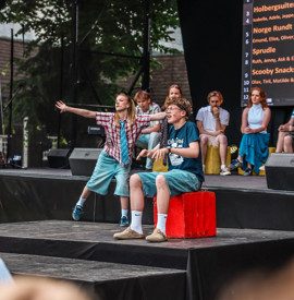 Jeppe Torjussen-Rui på rød kloss, med jente fra improlaget. Motstanderlaget sitter i bakgrunnen.