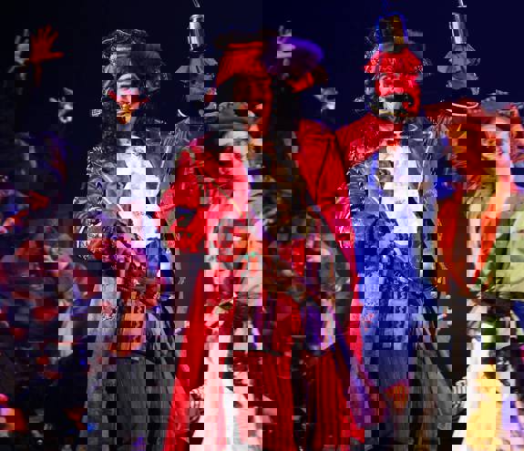 En mann kledd som Kaptein Krok fra Peter Pan, i full piratdrakt med hatt, klær i gammel stil og krok-hånd.