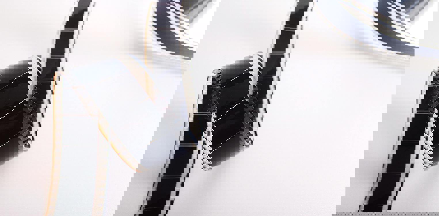 Gammeldags filmrull som ligger krøllet mot hvit bakgrunn. Bilde av Pietro Jeng: https://www.pexels.com/nb-no/bilde/65128/