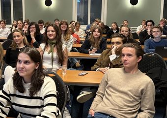 Ungdommer sitter i klasseromsoppsett og følger med på skolerevykurs.