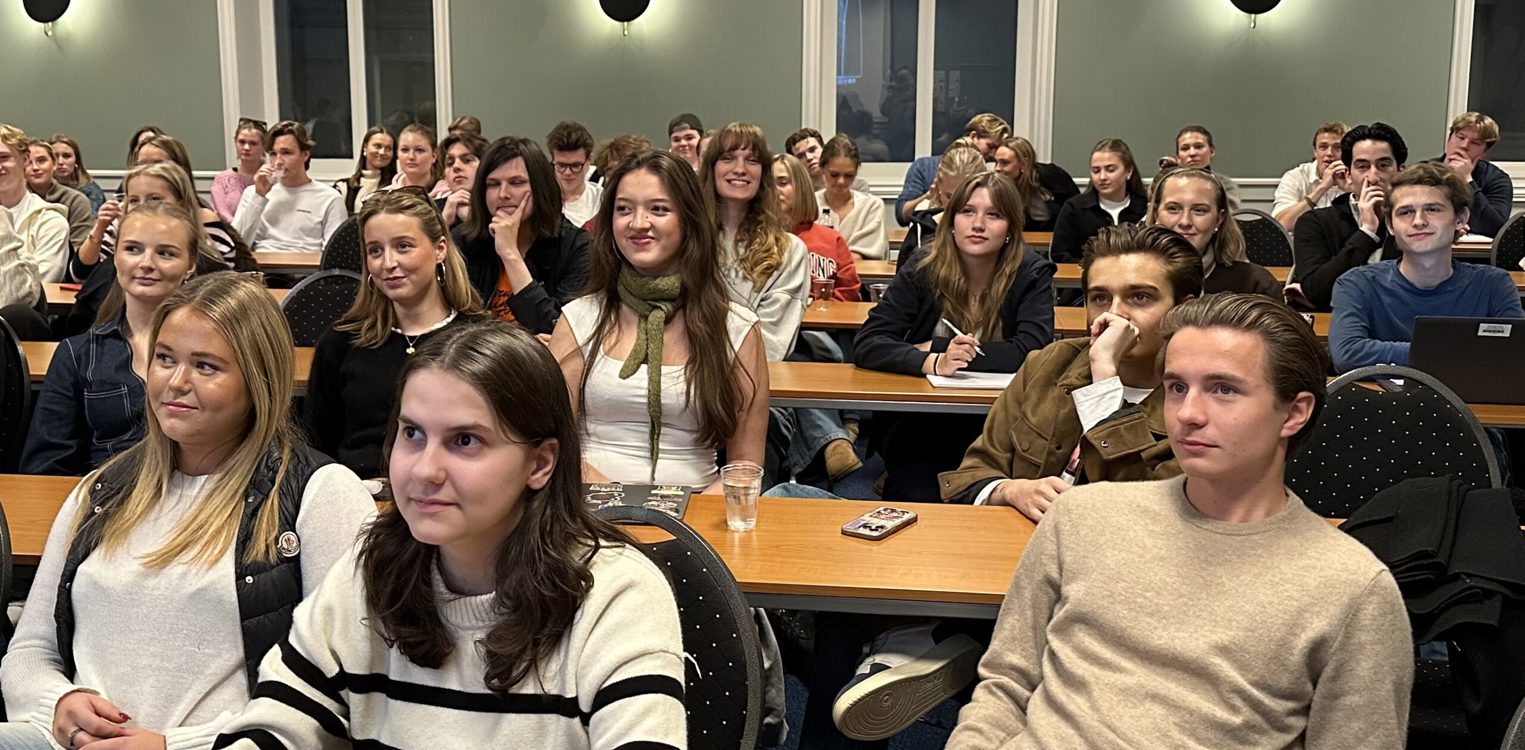 Ungdommer sitter i klasseromsoppsett og følger med på skolerevykurs.